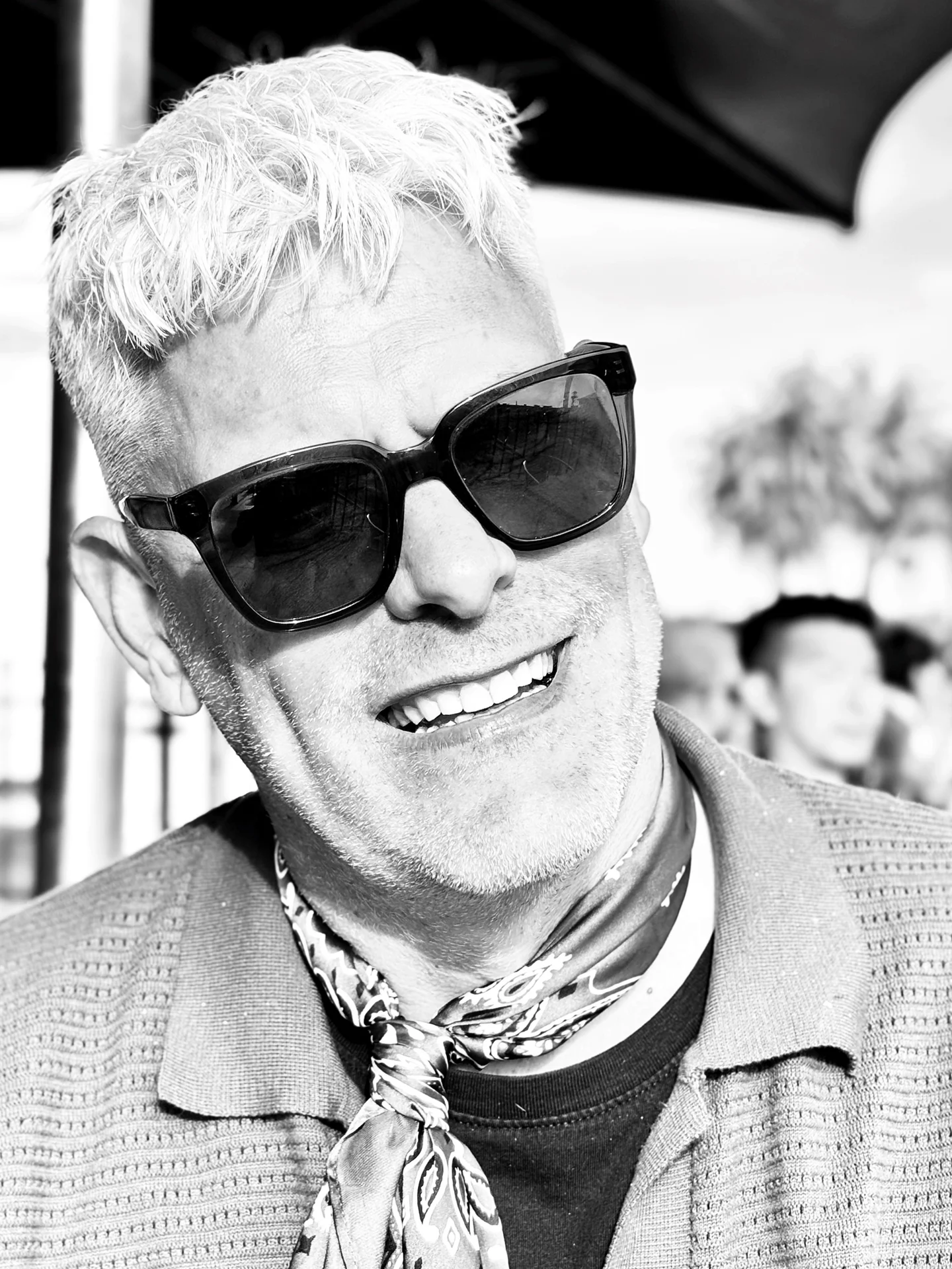 Black and white portrait of Brian R. wearing sunglasses and a neck scarf.